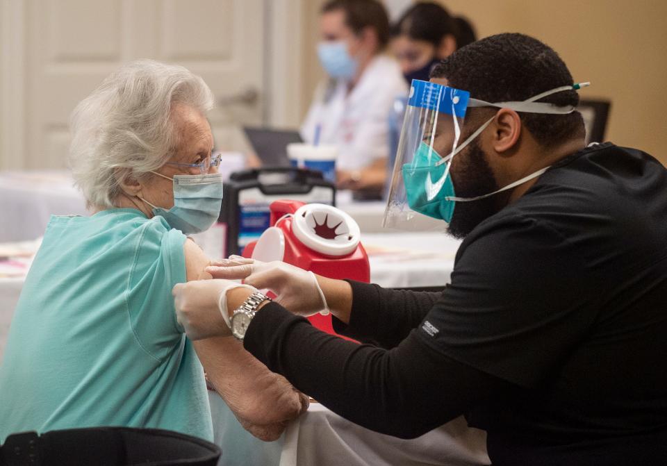 Nurse Johnathan Bell gives Allee Palmer the Pfizer-BioNTech vaccine at The Waterford on Highland Colony in Ridgeland, Miss., on Jan. 20.