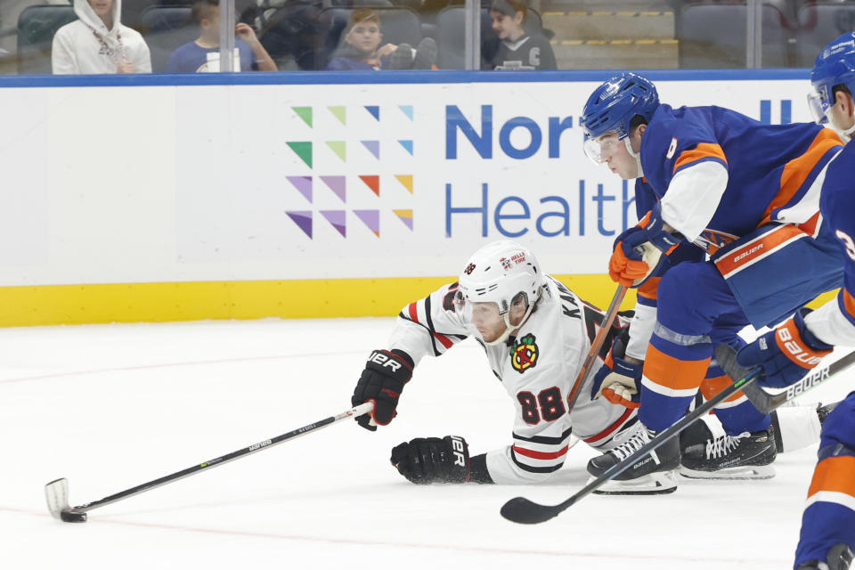 Chicago Blackhawks right wing Patrick Kane (88) tries to score after falling to the ice while pursued by New York Islanders defenseman Noah Dobson during the third period of an NHL hockey game Sunday, Dec. 5, 2021, in Elmont, N.Y. (AP Photo/Corey Sipkin).