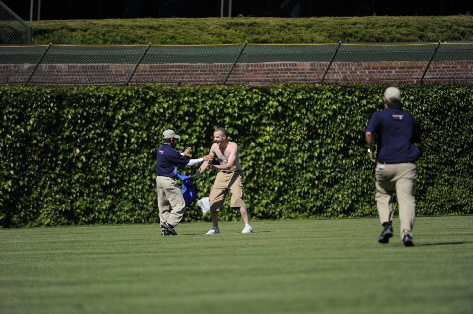 Security subdues fan after he ran onto the field after the game between the St. Louis Cardinals and Chicago Cubs on May 28, 2010 at Wrigley Field in Chicago, Illinois. The Cardinals defeated the Cubs 7-1. (Photo by Ron Vesely/MLB Photos via Getty Images)