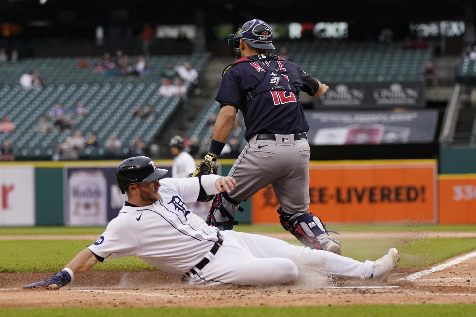 Detroit Tigers' Robbie Grossman scores on a single by Javier Baez as Cleveland Guardians catcher Luke Maile (12) waits on the throw during the first inning of a baseball game, Thursday, May 26, 2022, in Detroit. (AP Photo/Carlos Osorio)