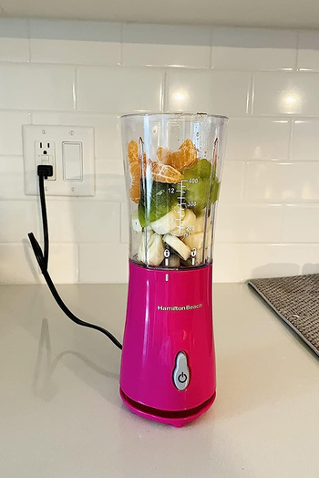 a reviewer's pink blender with fruit un blended