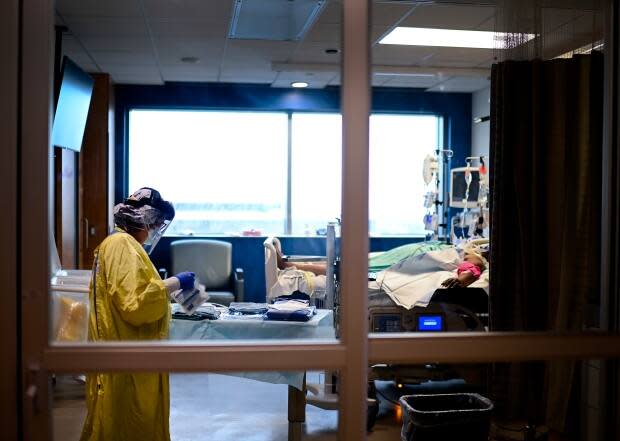 A health-care worker cares for a COVID-19 patient in the ICU at Toronto's Humber River Hospital. A number of Ontario medical professionals fear that they may be forced to start triaging ICU patients within weeks. (Nathan Denette/The Canadian Press - image credit)