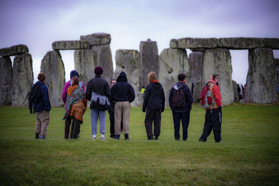 People view the stones during Summer Solstice at Stonehenge, where some people jumped over the fence to enter the stone-circle to watch the sun rise at dawn of the longest day of the year in the UK, in Amesbury, England, Monday June 21, 2021. The prehistoric monument of ancient stones have been officially closed for the celebrations due to the coronavirus lockdown, but groups of people ignored the lockdown to mark the Solstice, watched by low key security. (Ben Birchall/PA via AP)