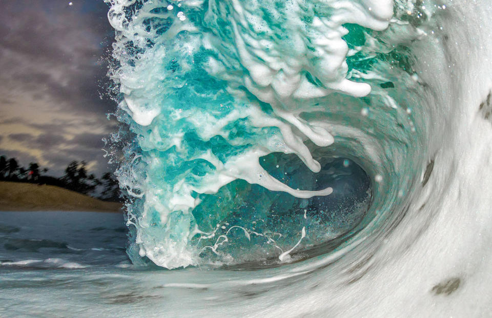 <p>A rolling wave during stormy conditions at the shore of the island of Oahu. (Photo: Marco Mitre/Caters News) </p>