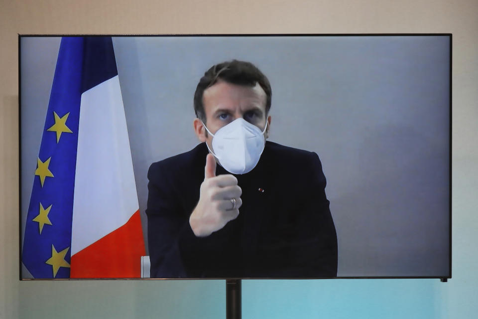 French President Emmanuel Macron is seen on a screen as he attends by video conference a round table for the National Humanitarian Conference (NHC), taken at the Foreign Ministry in Paris,Thursday, Dec. 17, 2020. French President Emmanuel Macron tested positive for COVID-19 Thursday following a week in which he met with numerous European leaders. The French and Spanish prime ministers and EU Council president were among many top officials self-isolating because they had recent contact with him. (Charles Platiau/Pool via AP)