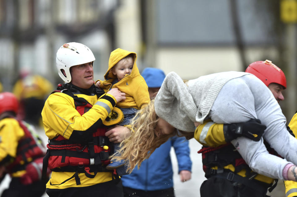 Rescue operations continue as emergency services take families to safety, after flooding in Nantgarw, Wales, Sunday, Feb. 16, 2020. Storm Dennis roared across Britain on Sunday, lashing towns and cities with high winds and dumping so much rain that authorities urged residents to protect themselves from "life-threatening floods" in Wales and Scotland. (Ben Birchall/PA via AP)