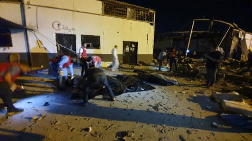 Emergency workers recover bodies after an air strike on a migrant detention centre in Libya