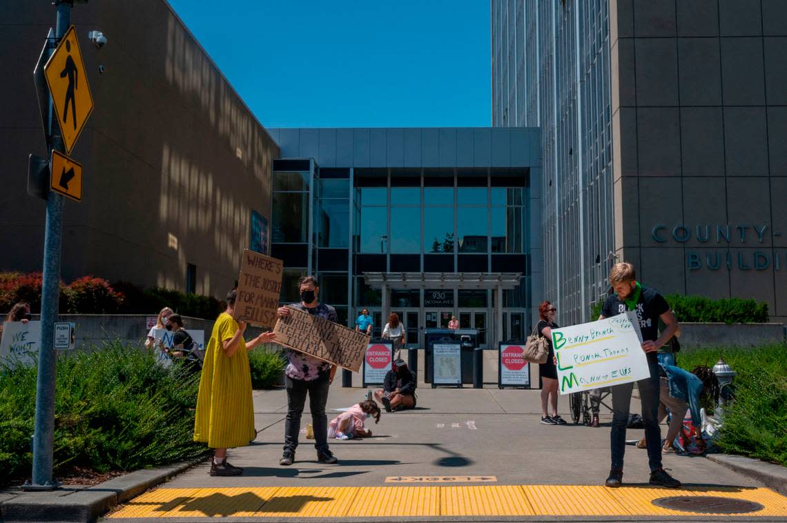 Protestors in support of Manny Ellis stand outside the County-City Building prior to the start of a motion hearing in Pierce County Superior on Friday, July 1, 2022. The hearing was on whether the city of Tacoma should be required to release internal interviews from police officers who were witnesses to the death of Manny Ellis.