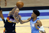 Phoenix Suns guard Devin Booker (1) is fouled by Houston Rockets center Christian Wood (35) while passing the ball during the second half of an NBA basketball game Wednesday, Jan. 20, 2021, in Houston. (AP Photo/Michael Wyke)