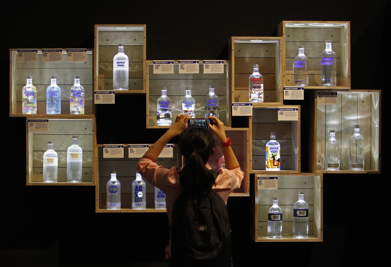 A visitor takes photos of limited edition Absolut Vodka bottles at the "Absolut Canvas" vodka exhibition at the Singapore National Museum
