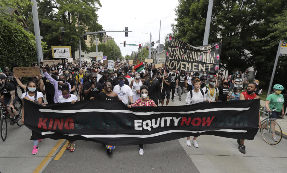 People taking part in a Juneteenth march travel down 23rd Ave. in Seattle, Friday, June 19, 2020. Thousands of people marched to honor the Juneteenth holiday and to protest against police violence and racism. (AP Photo/Ted S. Warren)