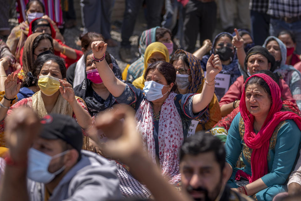 Kashmiri Hindus, locally known as Pandits, block a road during a protest against the killing of Rahul Bhat, also a Pandit, on the outskirts of Srinagar, Indian controlled Kashmir, Friday, May 13, 2022. Hindus in Indian-controlled Kashmir staged protests on Friday a day after assailants shot and killed the government employee from the minority community. It was the first time that Pandits, an estimated 200,000 of whom fled Kashmir after an anti-India rebellion erupted in 1989, simultaneously organized street protests at several places in the Muslim-majority region. (AP Photo/Dar Yasin)