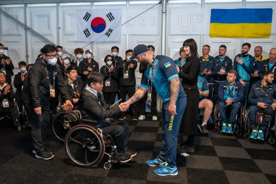 Team Korea presenting a collection of money and traditional Korean gifts to Team Ukraine (Aaron Chown/PA) (PA Wire)