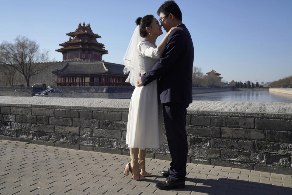Groom Dong Yangfeng and bride Wang Sai pose for photos near the Forbidden City in Beijing on Sunday, Dec. 20, 2020. Lovebirds in China are embracing a sense of normalcy as the COVID pandemic appears to be under control in the country where it was first detected. (AP Photo/Ng Han Guan)