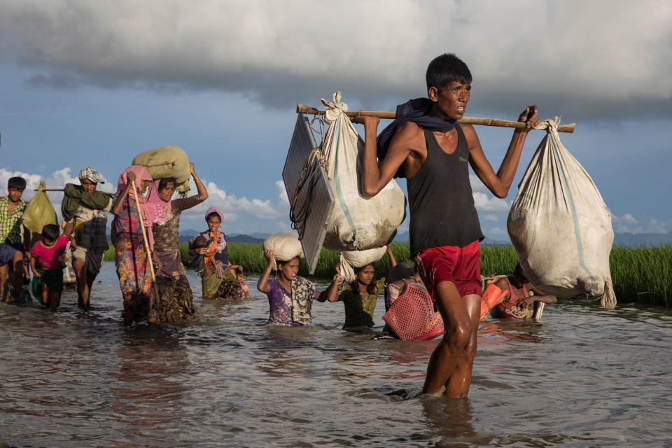 <p>Thousands of Rohingya refugees fleeing from Myanmar walk along a muddy rice field after crossing the border in Palang Khali, Cox’s Bazar, Bangladesh, on October 9, 2017. (Photograph by Paula Bronstein/Getty Images) </p>