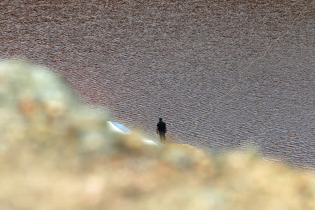 Á forensic officer searches Kokkinopezoula lake, also known as "red lake", for possible bodies of victims of a suspected serial killer near the village of Mitsero, Cyprus, May 1, 2019. REUTERS/Yiannis Kourtoglou