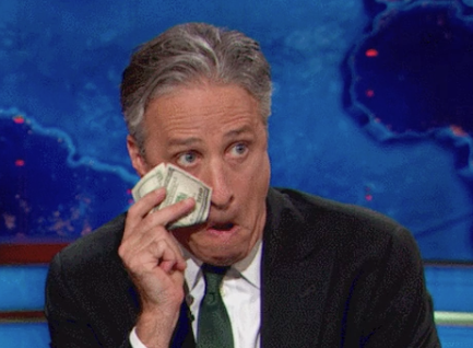 Jon Stewart wiping his face with money