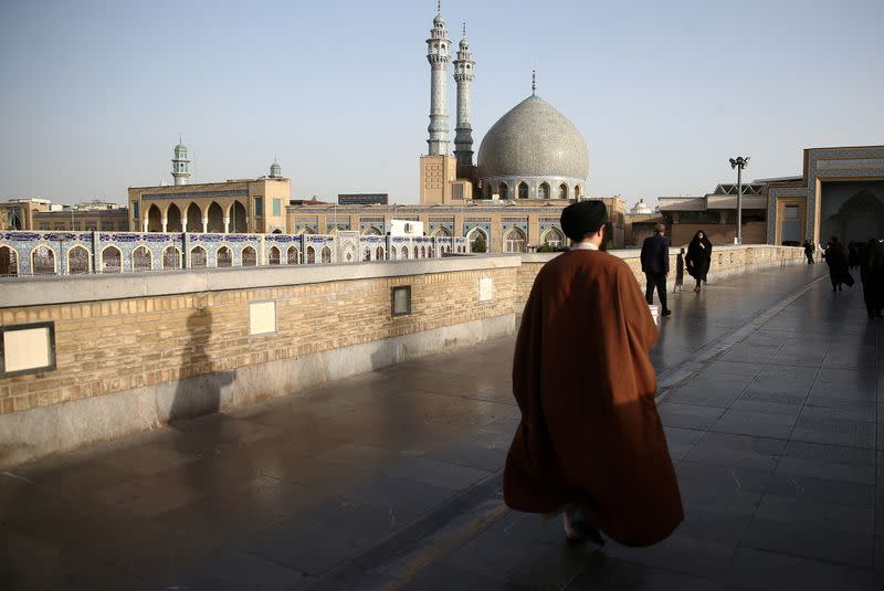 FILE PHOTO: An Iranian cleric walks in front of the Shrine of Fatima Masumeh in Qom