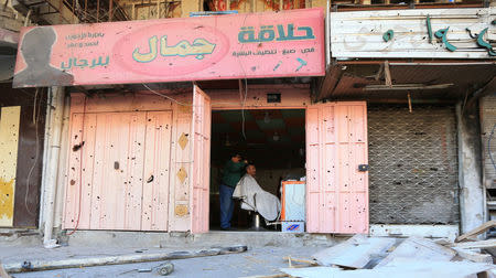 A barber cuts hair at a barber shop in Mosul, Iraq, January 10, 2018. Picture taken January 10, 2018. To match Special Report IRAQ-MOSUL/OFFICIAL REUTERS/Ari Jalal