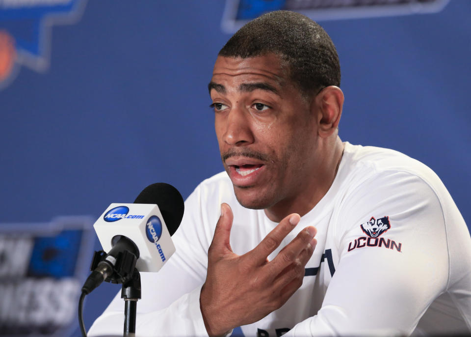 FILE - Connecticut coach Kevin Ollie speaks during a news conference ahead of a second-round men's college basketball game in the NCAA Tournament in Des Moines, Iowa, March 18, 2016. An independent arbiter has ruled that UConn improperly fired former men's basketball coach Kevin Ollie and must pay him more than $11 million, Ollie's lawyer said Thursday, Jan. 20, 2022. (AP Photo/Nati Harnik, File)