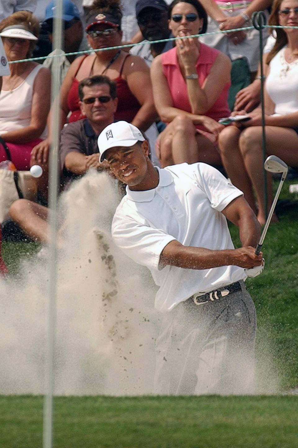 FILE - In this May 13, 2005, file photo, Tiger Woods hits out of a bunker to the 18th green during the second round of the Byron Nelson Championship in Irving, Texas. Woods made bogey to miss the cut, ending his record streak of 142 consecutive cuts made. (AP Photo/Tony Gutierrez, File)