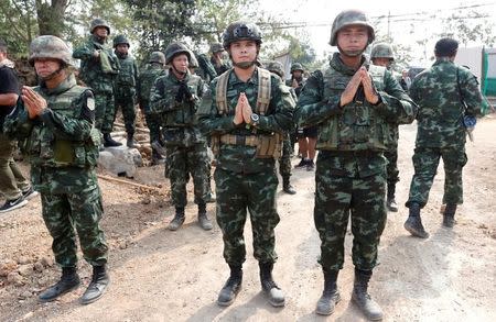 Soldiers pray and stand guard as Buddhist monks gather at Dhammakaya temple, in Pathum Thani province, Thailand February 23, 2017. REUTERS/Chaiwat Subprasom