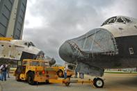 Space Shuttle Endeavour (R), leaving the Orbiter Processing Facility on its way to the Vehicle Assembly Building (VAB), passes Space Shuttle Discovery at Kennedy Space Center August 11, 2011 in Cape Canaveral, Florida. Space Shuttles Endeavour and Discovery switched buildings as they are being decommissioned with the end of the Shuttle program. (Photo by Roberto Gonzalez/Getty Images)