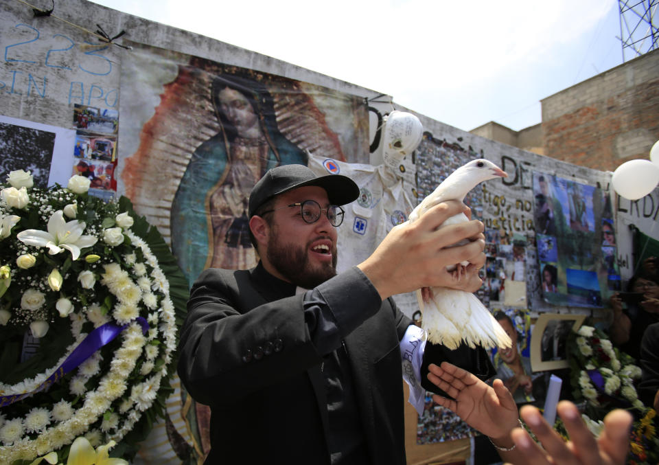 A priest releases a dove during a memorial ceremony in front of the site at Alvaro Obregon 286, where 49 died when their office building collapsed in last year's 7.1 magnitude earthquake, in Mexico City, Wednesday, Sept. 19, 2018. Across the city, memorials were held at sites where hundreds perished in the Sept. 19, 2017 quake.(AP Photo/Rebecca Blackwell)