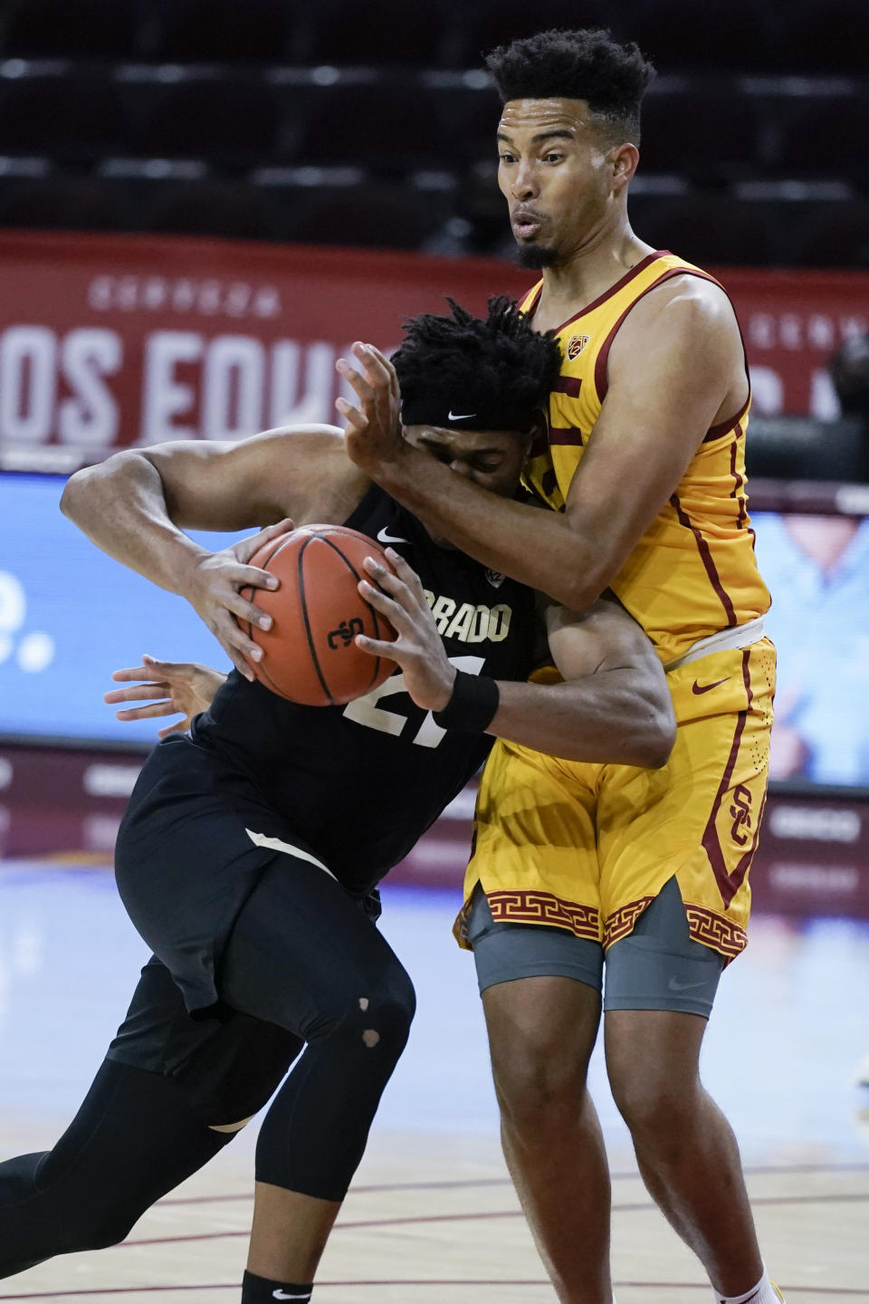 Colorado's Evan Battey, left, is defended closely by Southern California's Isaiah Mobley during the first half of an NCAA college basketball game Thursday, Dec. 31, 2020, in Los Angeles. (AP Photo/Jae C. Hong)