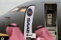 Vistors walk past a GlobalEye aircraft, manufactured by Saab Technologies, on static display during the fifth day of Dubai Air Show in Dubai