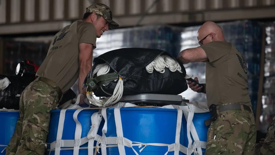 New Zealand Army Pvt. Alexander Lam Sam and Staff Sgt. Geoffrey Troughton inspect and clean pallets on July 11 to prepare for a coalition airdrop near Andersen Air Force Base, Guam. The airdrop, part of Mobility Guardian 23, showed how the U.S. and its allies are capable of resupplying remote areas. (Staff Sgt. Bailee Ann Darbasie/Air Force)