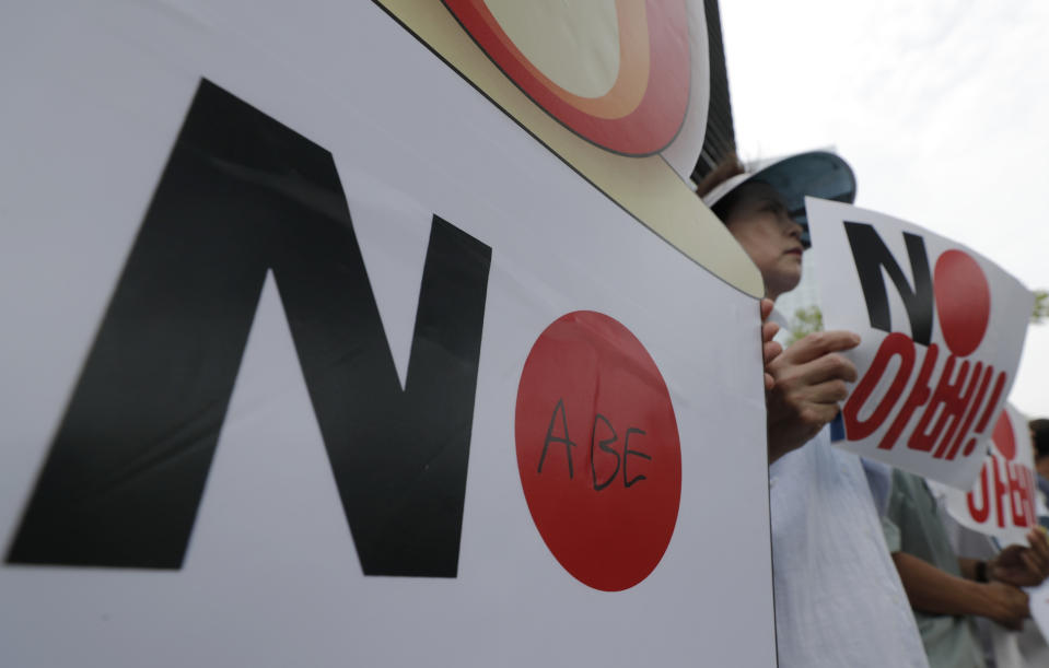 South Korean protesters hold signs during a rally denouncing the Japanese Prime Minister Shinzo Abe in front of the Japanese embassy in Seoul, South Korea, Thursday, Aug. 8, 2019. (AP Photo/Lee Jin-man)