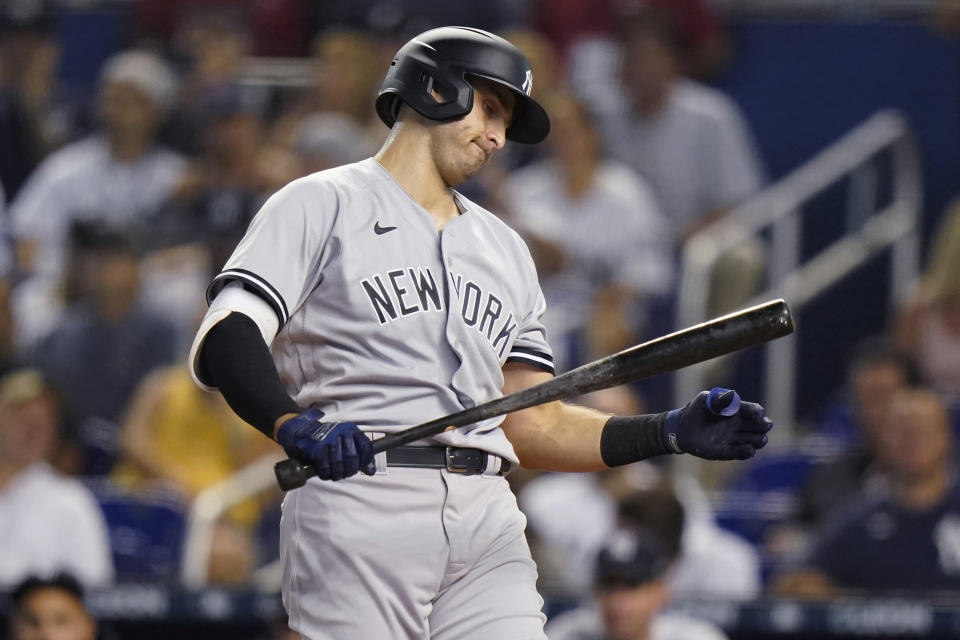 New York Yankees' Joey Gallo looks at his bat after striking out during the first inning of the team's baseball game against the Miami Marlins, Friday, July 30, 2021, in Miami. (AP Photo/Lynne Sladky)