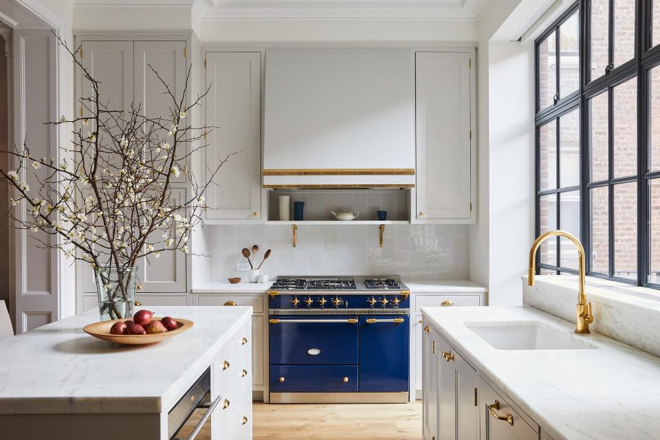 Marble countertops, brass fixtures, subdued zellige tiles, and a Lacanche range underscore the house’s traditional feel in the kitchen, which was designed by Roberts’s team under the supervision of project manager Josh Lekwa. “I love being able to sit at the kitchen counter and look out at the garden,” says the homeowner of the back wall of windows.