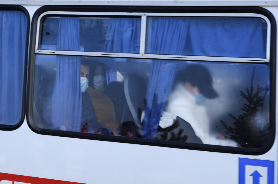 Busses with passengers from the Ukrainian aircraft chartered by the Ukrainian government for evacuation from the Chinese city of Wuhan, leave the the gate upon their landing at airport outside Kharkiv, Ukraine, Thursday, Feb. 20, 2020. Ukraine's effort to evacuate more than 70 people from China due to the outbreak of the new COVID-19 virus was delayed because of bad weather as evacuees travel to a hospital where they are expected to be quarantined. (AP Photo/Igor Chekachkov)