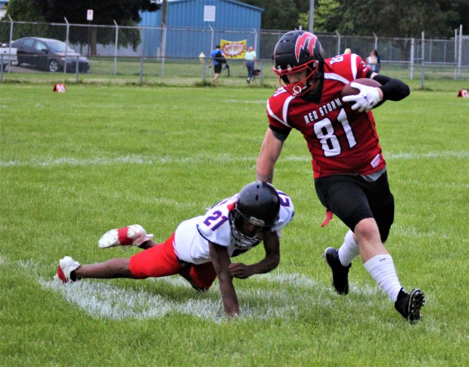 Southeast Michigan Red Storm tight end Tyler Hammack (right) shakes off a tackle after making a catch against the West Michigan Patriots on Saturday, June 11, 2022.