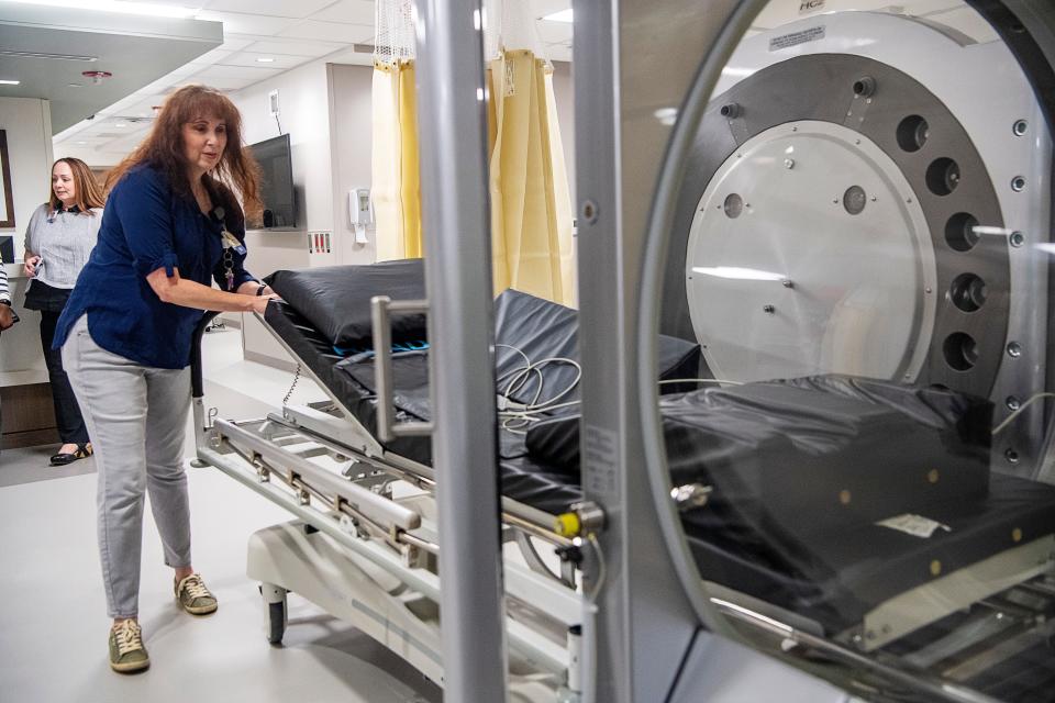 Dawn Wascoe, RN, demonstrates how she would move a patient into one of Mission’s hyperbaric oxygen chambers July 27, 2023.