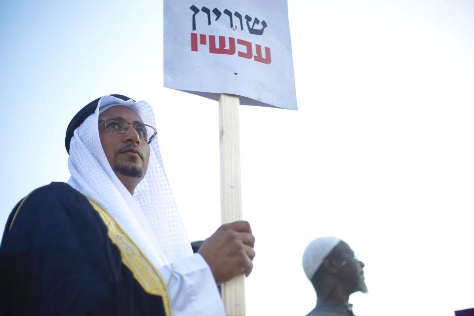 An Arab Israeli Arab man holds a sign that reads "Equality now" during a protest against the Jewish nation bill in Tel Aviv, Israel, Saturday, Aug. 11, 2018. The recently passed law that enshrines Israel's Jewish character and downgrades the standing of Arabic from an official to a "special" language. (AP Photo/Ariel Schalit)