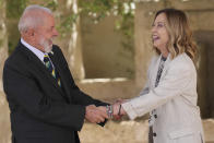 Luiz Inácio Lula da Silva, President of Brazil, left, shares a light moment with Italy's Prime Minister Giorgia Meloni as he is welcomed on day two of the 50th G7 summit at Borgo Egnazia, southern Italy, on Friday, June 14, 2024. (Christopher Furlong/Pool Photo via AP)