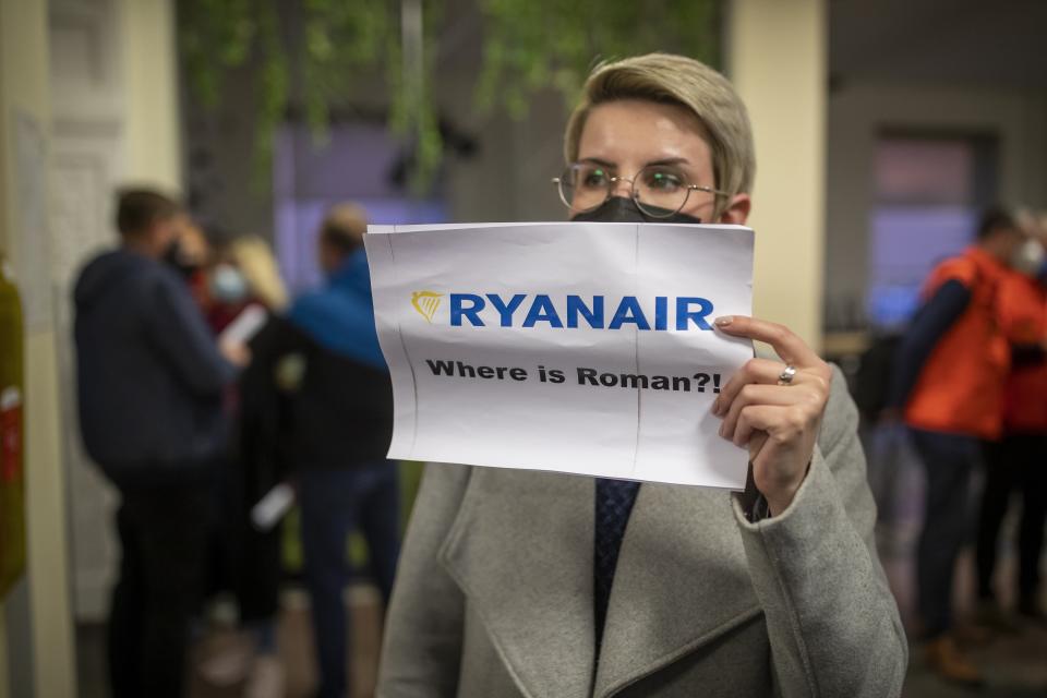 A woman holds a poster reads "where is Raman Pratasevich?!" as she waits to see passengers of the Ryanair plane with registration number SP-RSM, carrying opposition figure Raman Pratasevich which was traveling from Athens to Vilnius and was diverted to Minsk after a bomb threat, after its landing at the International Airport outside Vilnius, Lithuania, Sunday, May 23, 2021. The presidential press service said President Alexander Lukashenko personally ordered that a MiG-29 fighter jet accompany the Ryanair plane carrying opposition figure Raman Pratasevich and traveling from Athens, Greece, to Vilnius, Lithuania to the airport in the capital Minsk. (AP Photo/Mindaugas Kulbis)