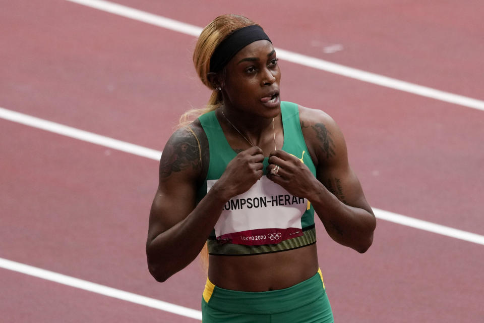 Elaine Thompson-Herah, of Jamaica, wins a heat in the women's 100-meter run at the 2020 Summer Olympics, Friday, July 30, 2021, in Tokyo. (AP Photo/Charlie Riedel)