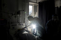 Chief of ICU department Dr. Valentyn Koroliuk speaks to a patient with coronavirus at the city hospital 1 in Rivne, Ukraine, Friday, Oct. 22, 2021. In Rivne, 300 kilometers (190 miles) west of Kyiv, the city hospital is swamped with COVID-19 patients and doctors say the situation is worse than during the wave of infections early in the pandemic that severely strained the health system. Ukraine's coronavirus infections and deaths reached all-time highs for a second straight day Friday, in a growing challenge for the country with one of Europe's lowest shares of vaccinated people. (AP Photo/Evgeniy Maloletka)