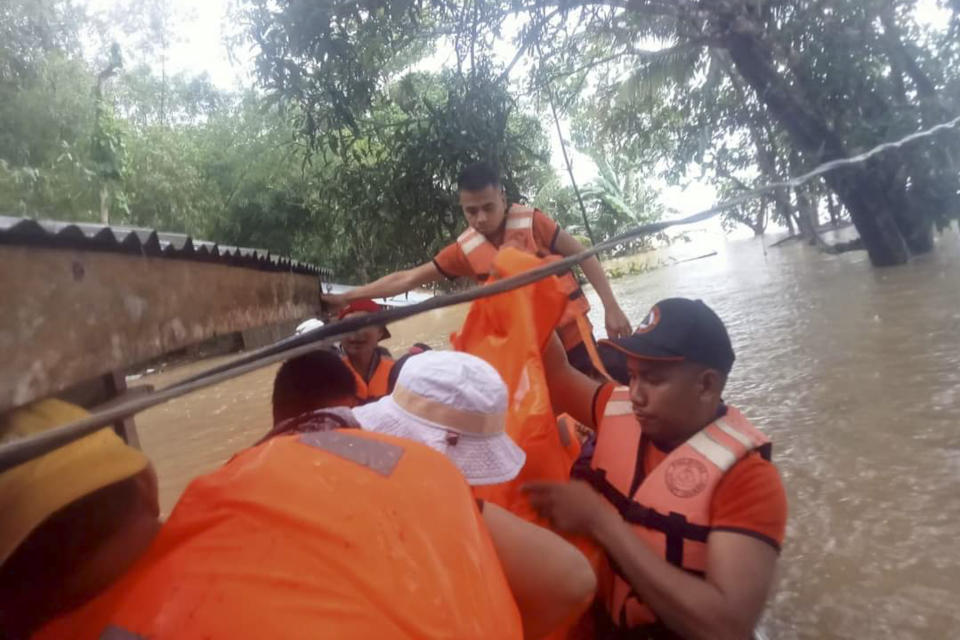 In this photo provided by the Philippine Coast Guard, rescuers use boats to evacuate residents from flooded areas due to Tropical Storm Nalgae at Sigma, Capiz province, Philippines on Friday Oct. 28, 2022. Floodwaters rapidly rose in many low-lying villages, forcing some villagers to climb to their roofs, where they were rescued by army troops, police and volunteers, officials said. (Philippine Coast Guard via AP)