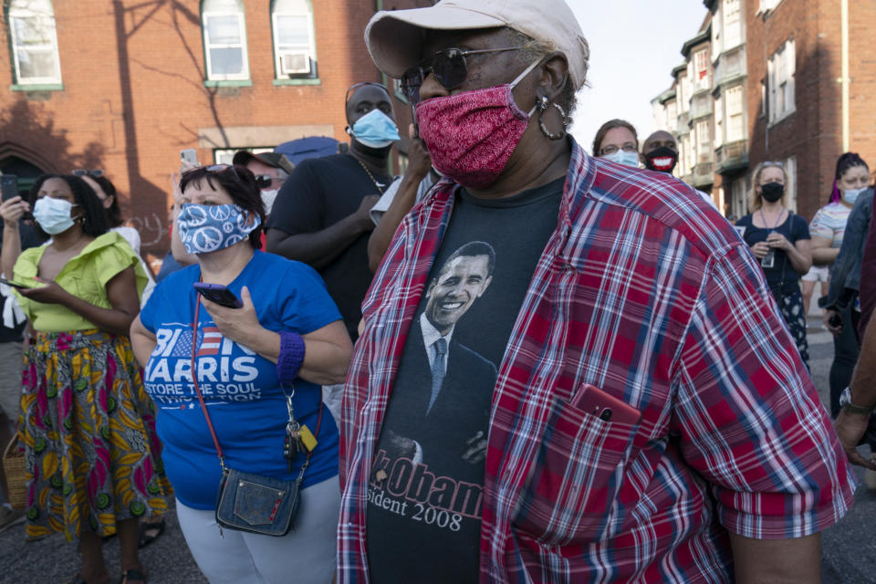 Supporters of Democratic presidential candidate former Vice President Joe Biden, including a person with a shirt with a photo of former President Barack Obama, wait outside of the AFL-CIO headquarters in Harrisburg, Pa., Monday, Sept. 7, 2020. (AP Photo/Carolyn Kaster)