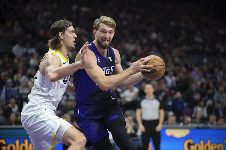 Utah Jazz forward Kelly Olynyk (41) defends against Sacramento Kings forward Domantas Sabonis (10) during the first quarter of an NBA basketball game in Sacramento, Calif., Saturday, Dec. 16, 2023. (AP Photo/José Luis Villegas)