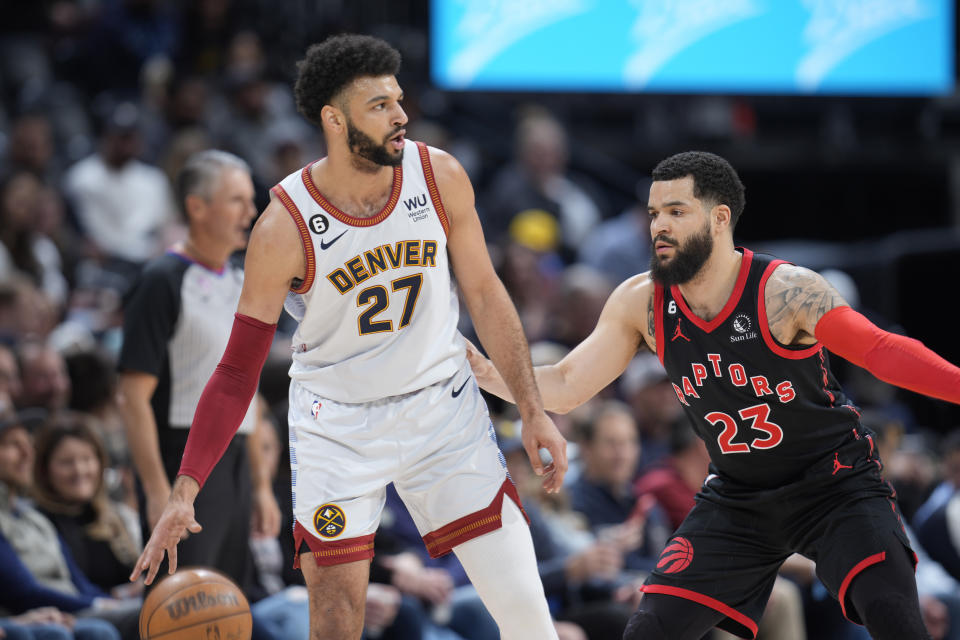 Denver Nuggets guard Jamal Murray, left, looks to pass the ball as Toronto Raptors guard Fred VanVleet defends in the first half of an NBA basketball game, Monday, March 6, 2023, in Denver. (AP Photo/David Zalubowski)