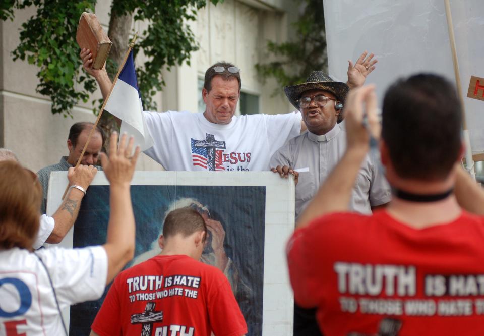 ABORTION CLINIC PROTEST--Flip Benham, director of Operation Save America, raises his Bible and bows his head as the Rev. Ronnie Wallace (second from right) of Charlotte North Carolina, leads a group of Pro-Life supporters in prayer during a rally Saturday outside the sole abortion clinic life in Jackson, MS, the Women's Health Organization in Jackson. Photo by Barbara Gauntt, The Clarion-Ledger.
