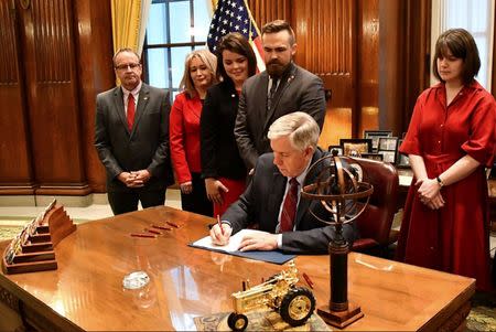 Missouri Governor Mike Parson signs Bill 126 into law banning abortion beginning in the eighth week of pregnancy, alongside state House and Senate members and pro-life coalition leaders at his office in Jefferson City, Missouri, U.S., May 24, 2019. Office of Governor Michael L. Parson/Handout via REUTERS