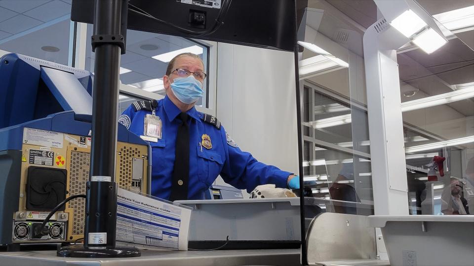 TSA security officer Antoinette Spanitz checks a piece of carry-on luggage that the airport's new Checkpoint Property Screening System's tagged for a closer look. She is looking at a 3-D image of what's inside after the bag was automatically diverted to her station behind glass.