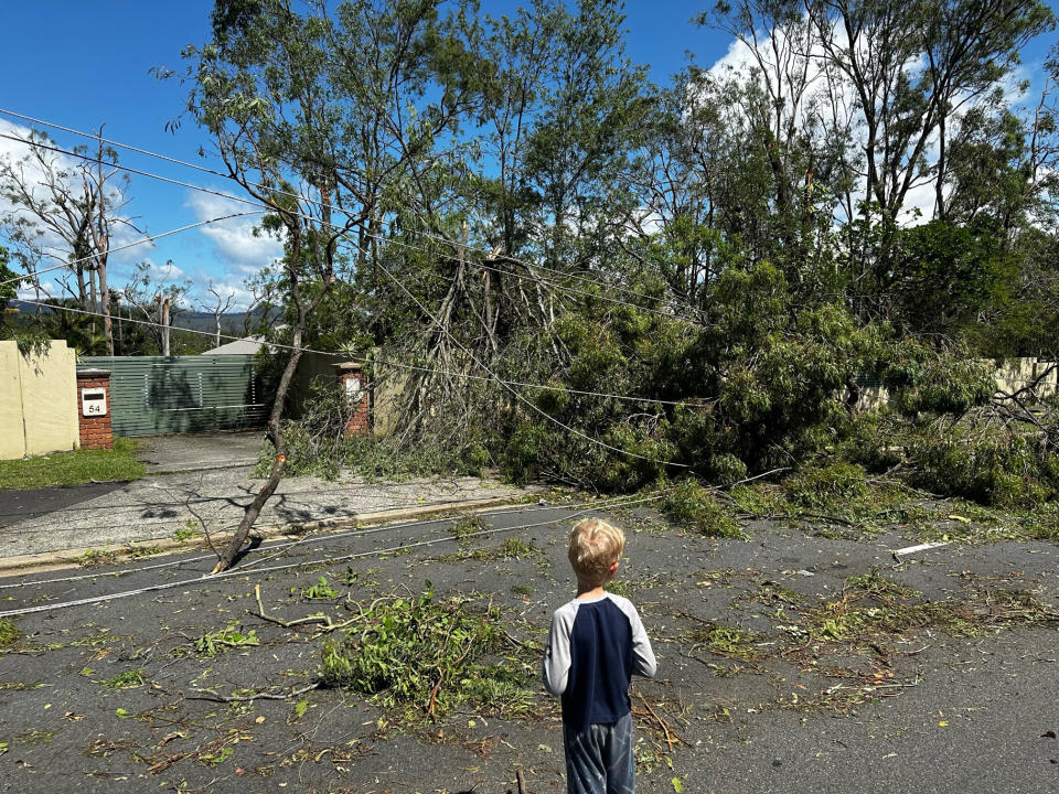 A boy looking at the storm damage.